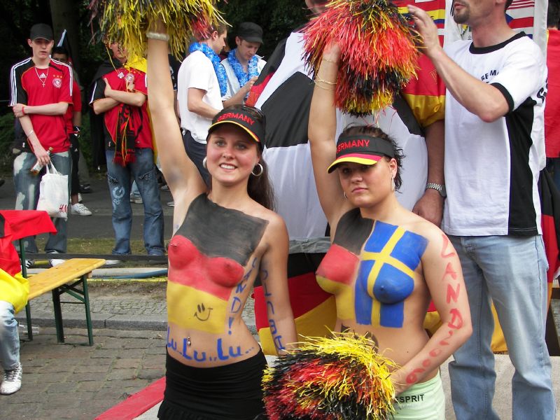 Topless girls with torso painted in German and Sweden flags.